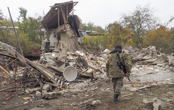 06.11.2020, Aserbaidschan, Stepanakert: Armenische Soldaten inspizieren die Ruinen eines Hauses, das durch Beschuss von aserbaidschanischen Truppen zerstört wurde. Bei neuen schweren Gefechten in der  ...