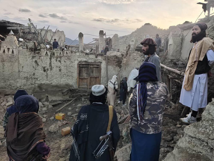 In this photo released by a state-run news agency Bakhtar, Afghans look at destruction caused by an earthquake in the province of Paktika, eastern Afghanistan, Wednesday, June 22, 2022. (Bakhtar News  ...