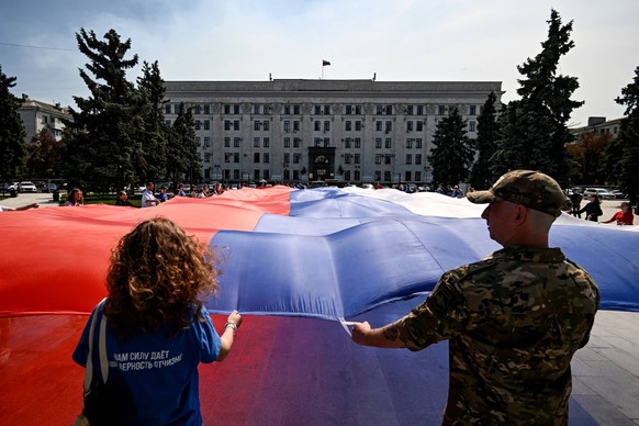 Russia Regions National Flag Day 8748011 22.08.2024 Young activists unfurl the national flag during Russia s National Flag Day celebrations in Teatralnaya Square, in Lugansk, Lugansk People s Republic ...