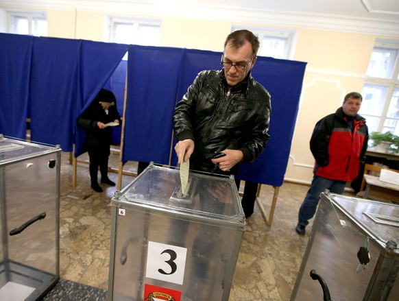 ITAR-TASS: SEVASTOPOL, UKRAINE. MARCH 16, 2014. A man casts her ballot at a polling station during a referendum on the status of Crimea. People in the Autonomous Republic of Crimea have to choose whet ...