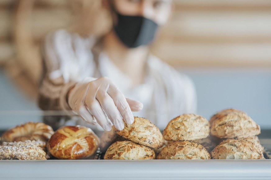 a gloved hand that chooses a pastry