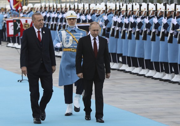Turkey's President Recep Tayyip Erdogan left, walks with Russia's President Vladimir Putin, centre, during a welcome ceremony, in Ankara, Turkey, Tuesday, April 3, 2018. Putin, on his first foreign vi ...