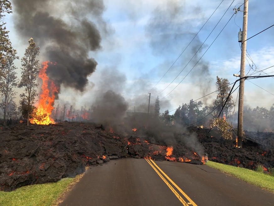 Lava advances along a street near a fissure in Leilani Estates, on Kilauea Volcano's lower East Rift Zone, Hawaii, the U.S., May 5, 2018. U.S. Geological Survey/Handout via REUTERS THIS IMAGE HAS BEEN ...