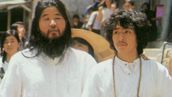 FILE - In this undated file photo, cult guru Shoko Asahara, left, of Aum Shinrikyo walks with Yoshihiro Inoue, then a close aid, in Tokyo. Japanese media reports say on Friday, July 6, 2018, Asahara,  ...