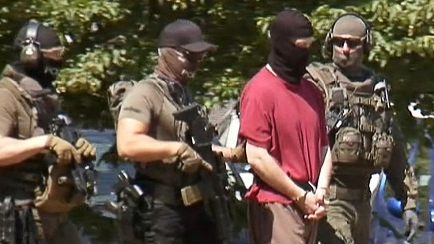 German special police escorts Stephan E., supected of killing the administrative chief of the city of Kassel Walter Luebcke, back to a helicopter after a hearing at the Federal Court in Karlsruhe, Ger ...