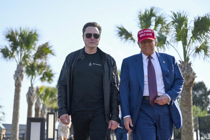 ARCHIV - 19.11.2024, USA, Brownsville: Der designierte US-Präsident Donald Trump (r) geht mit Elon Musk vor dem Start des sechsten Testflugs der SpaceX Starship-Rakete. (zu dpa: «Trump verlangt Hausha ...