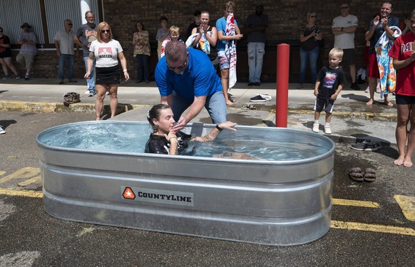 July 17, 2022, Canton, Georgia, USA: Gary Lamb, volunteer pastor at Action Church in a low-income section of this North Georgia town, baptizes a new believer in a water trough outside the modest store ...