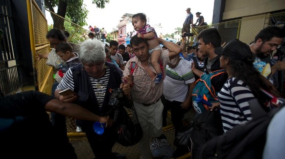 Flüchtlinge aus Honduras drängen ein Tor auf, um nach Mexiko zu gelangen.