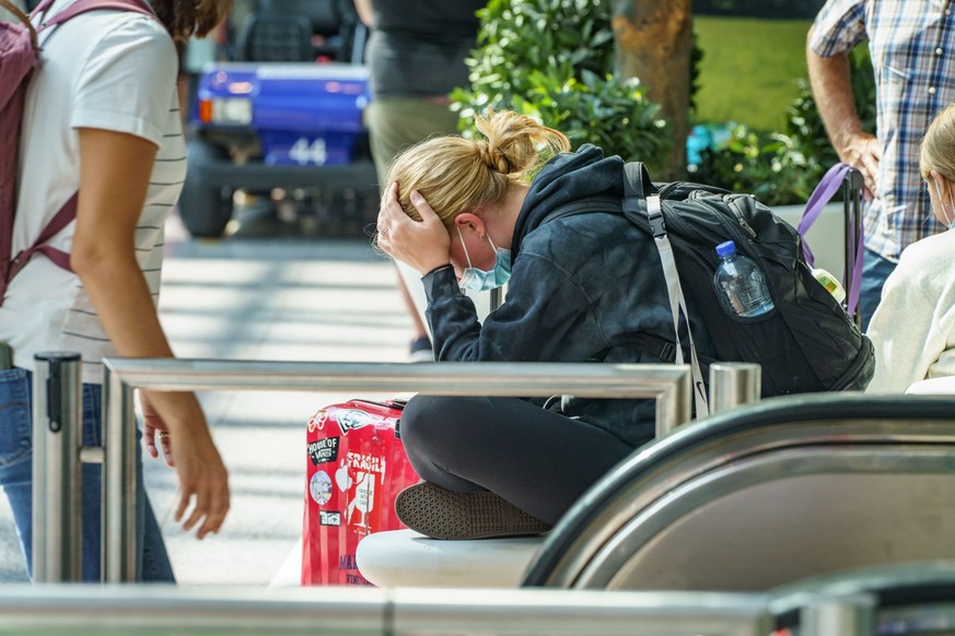 23.07.2022, Hessen, Frankfurt/Main: Eine Reisende wartet im Terminal 2 des Frankfurter Flughafens. Nach Beginn der Sommerferien in Hessen, Rheinland-Pfalz und dem Saarland kam es zu einem starken Andr ...