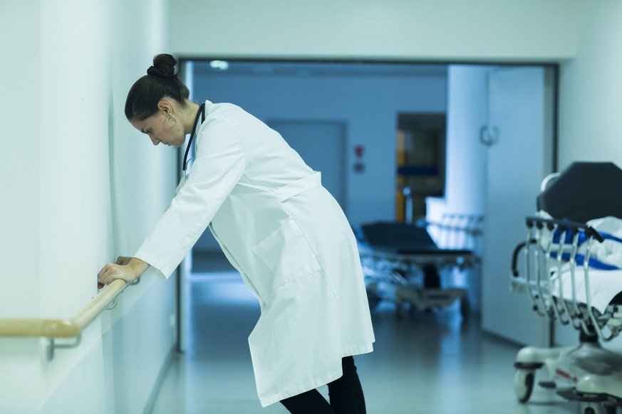 Overstressed young doctor standing in hospital corridor model released Symbolfoto property released PUBLICATIONxINxGERxSUIxAUTxHUNxONLY SGF000908