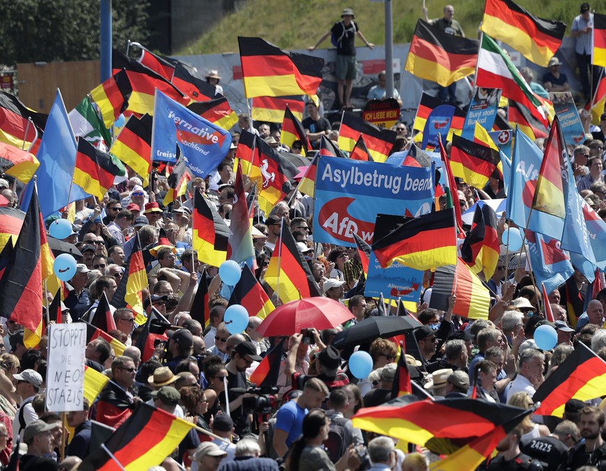 AfD supporters wave flags in Berlin, Germany, Sunday, May 27, 2018. The AfD that swept into Parliament last year on a wave of anti-migrant sentiment is staging a march Sunday through the heart of Berl ...