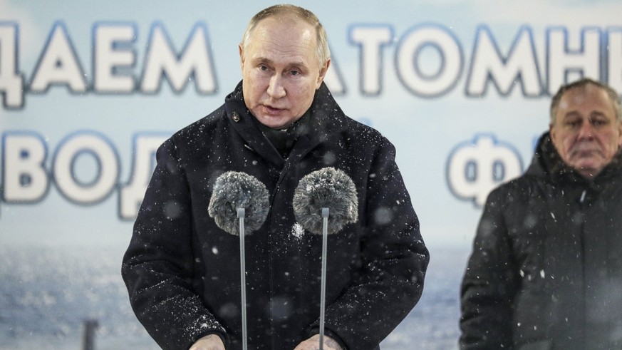 11.12.2023, Russland, Sewerodwinsk: Auf diesem von der staatlichen russischen Nachrichtenagentur Sputnik via AP veröffentlichten Foto hält Wladimir Putin (l), Präsident von Russland, eine Rede, währen ...