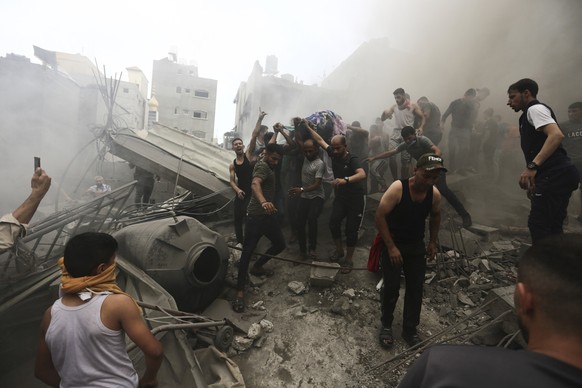 09.10.2023, Palästinensische Gebiete, Jabalia: Palästinenser entfernen eine Leiche aus den Trümmern eines Gebäudes nach einem israelischen Luftangriff auf das Flüchtlingslager Jabalia im Gazastreifen. ...