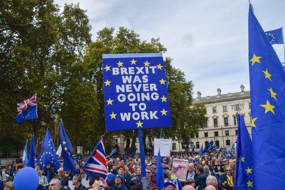 October 22, 2022, London, United Kingdom: A protester holds an anti-Brexit placard during the demonstration in Parliament Square. Thousands of people marched through Central London demanding that the ...
