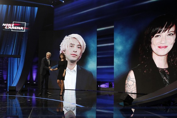 Italian actress Asia Argento is welcomed by TV host Massimo Gilletti, left, as a picture of US actor Jimmy Bennett is seen in background, during the Italian TV LA7 program &quot; Non e&#039; l&#039;Ar ...