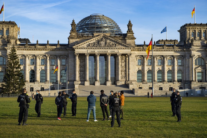 Berliner Stadtleben im Corona-Lockdown Polizisten kontrollieren Passanten auf ihre Mund-Nasen-Maske auf der Wiese vor dem Geb