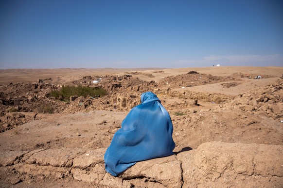 Herat Earthquake 10/10/2023 Herat, Afghanistan. An Afghan woman sits and watches the ruined village near Herat after the earthquake. Herat Herat Afghanistan Copyright: xOsmanxKhayyamx