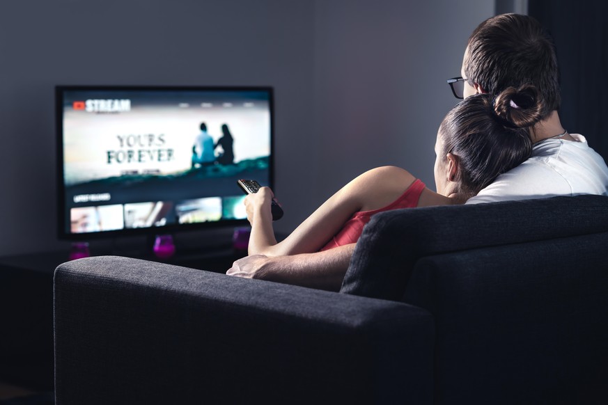 Movie stream service on smart tv. Couple watching series online. Woman choosing film or new season with remote control. Video on demand (VOD) site mockup on screen. Digital streaming network.