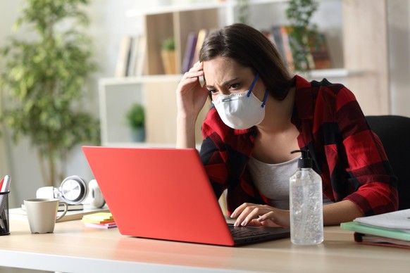 Sad student reading bad coronavirus news on laptop at home