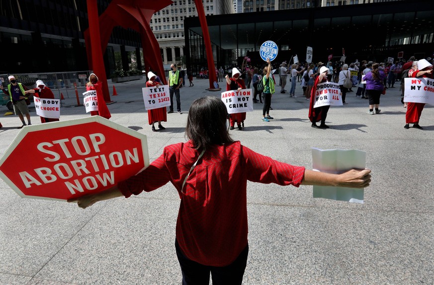 US-NEWS-CHICAGO-ABORTION-PROTESTS:-TB Anti-abortion activist Eileen Steffel of Glenview, Illinois, back to camera, faces a row of pointing pro-choice handmaids as several dozen abortion activists and  ...