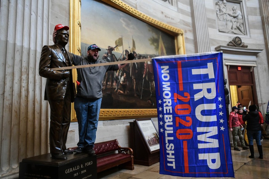 ARCHIV - 06.01.2021, USA, Washington: Ein Demonstrant schreit im US-Kapitol, nachdem Anhänger von US-Präsident Donald Trump das Gebäude gestürmt haben, in dem die Gesetzgeber den Wahlsieg des designie ...