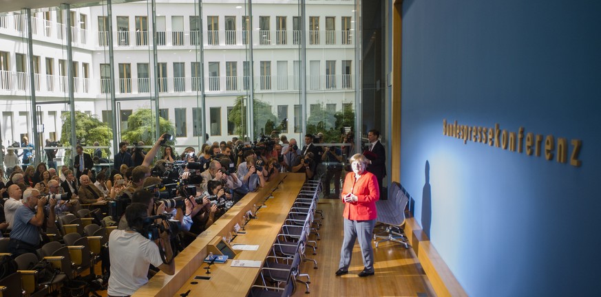 German Chancellor Angela Merkel casts a shadow when posing for a photo at the beginning of her annual summer press conference at the Bundespressekonferenz in Berlin, Germany, Friday, July 20, 2018. (A ...