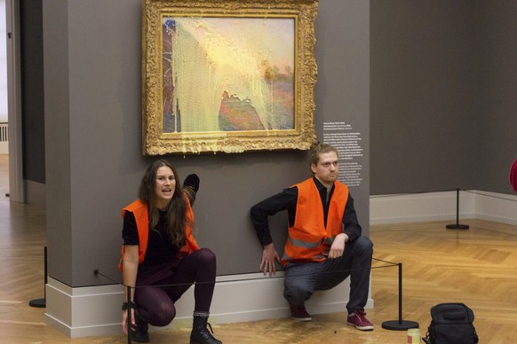 Climate protesters of Last Generation after throwing mashed potatoes at the Claude Monet painting &quot;Les Meules” at Potsdam’s Barberini Museum on Sunday Oct. 24, 2022, to protest fossil fuel extrac ...