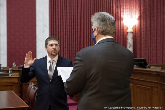 West Virginia House of Delegates member Derrick Evans, left, is given the oath of office Dec. 14, 2020, in the House chamber at the state Capitol in Charleston, W.Va. Evans recorded video of himself a ...