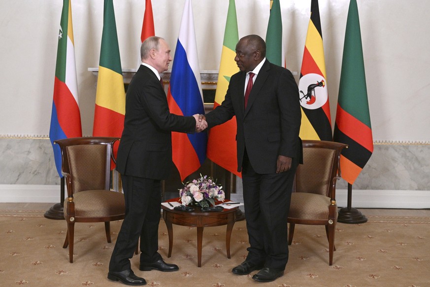 In this handout photo provided by Photo host Agency RIA Novosti, Russian President Vladimir Putin, left, and South African President Cyril Ramaphosa shake hands prior to their talks after a meeting wi ...