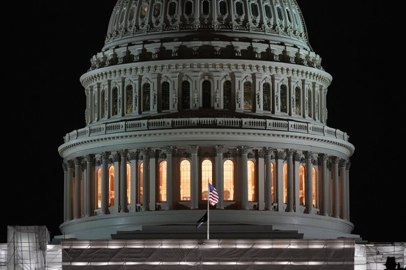 06.01.2023, USA, Washington: Die amerikanische Flagge weht auf dem US-Kapitol vor Sonnenaufgang am zweiten Jahrestag der gewaltsamen Attacke auf das US-Kapitol. Am 6. Januar 2021 hatten Anhänger des d ...