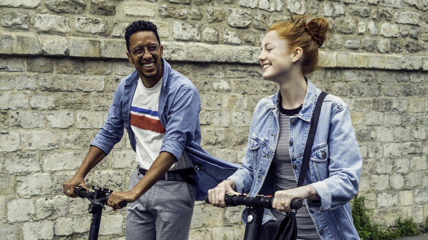 Couple riding push scooters PUBLICATIONxINxGERxSUIxAUTxONLY Copyright: Fr