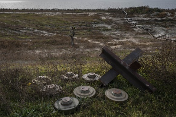 A Ukrainian sapper searches for mines on the field of a recently liberated village outskirts of Kherson, in southern Ukraine, Wednesday, Nov. 16, 2022. (AP Photo/Bernat Armangue)