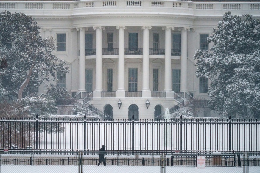 WASHINGTON, DC - JANUARY 06: A pedestrian walks past the White House grounds during a snowstorm on January 6, 2025, in Washington, DC. (Photo by J. David Ake/Getty Images)