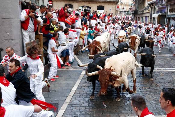 July 12, 2018 - Pamplona, northern Spain - Participants run next to Vitoriano del Rio fighting bulls on Mercaderes corner on the fourth bullrun of the San Fermin festival. Each day at 8am hundreds of  ...