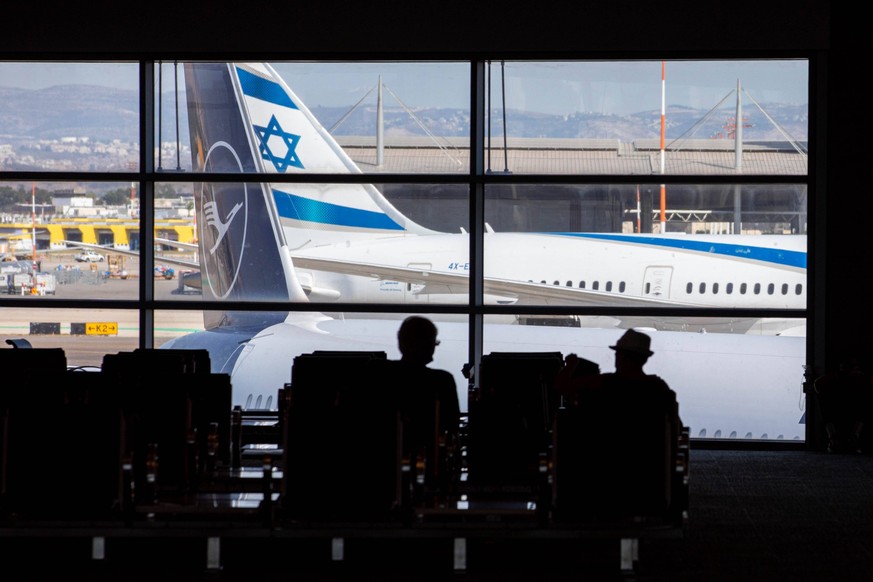 Symbolbild Flughafen TLV Israel, Flughafen Ben Gurion bei Tel-Aviv: Silhouette zwei Passagiere warten im Terminal sitzen vor einem Fenster mit zwei Flugzeuge von Lufthansa und El-Al. *** Symbol image  ...