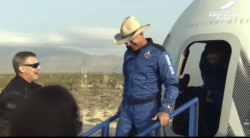 This photo provided by Blue Origin, Jeff Bezos, founder of Amazon and space tourism company Blue Origin, exits the Blue Origin&#039;s New Shepard capsule after it parachuted safely down to the launch  ...