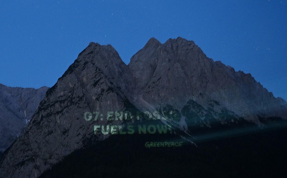 An die Waxensteine projiziert Greenpeace in den frühen Morgenstunden “G7: End Fossil Fuels Now”. Deutschland ist Gastgeber des G7-Gipfels (26. bis 28. Juni) wirtschaftsstarker Demokratien.