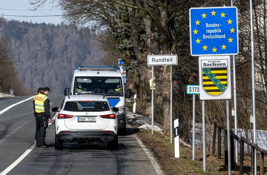 20.02.2021, Tschechien, Petrovice: Deutsche Polizeibeamte kontrollieren ein Fahrzeug am tschechisch-deutschen Grenz