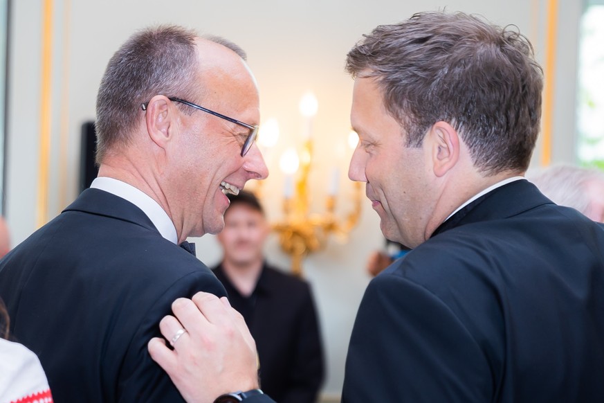 ARCHIV - 29.04.2022, Berlin: Friedrich Merz (l), CDU-Bundesvorsitzender, und Lars Klingbeil, SPD-Bundesvorsitzender, unterhalten sich zu Beginn beim Dinner des 69. Bundespresseballs im Hotel Adlon. Un ...