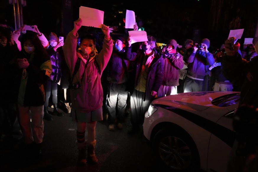 Protesters hold up blank papers and chant slogans as they march in protest in Beijing, Sunday, Nov. 27, 2022. Protesters angered by strict anti-virus measures called for China&#039;s powerful leader t ...