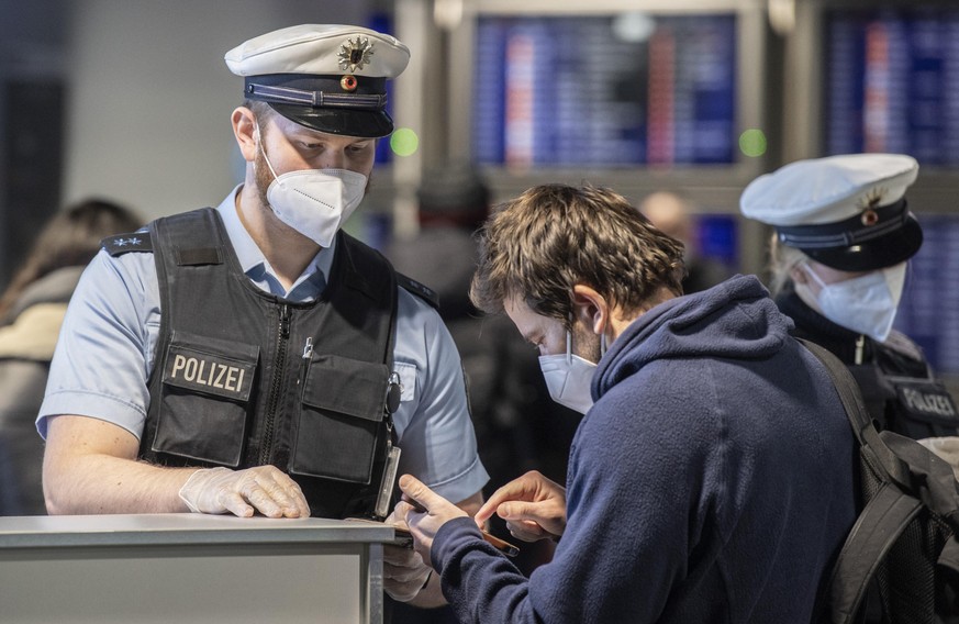 24.01.2021, Hessen, Frankfurt/Main: Beamte der Bundespolizei kontrollieren am Flughafen Frankfurt die Passagiere einer aus Prag gelandeten Passagiermaschine. Hintergrund ist die Entscheidung der Bunde ...