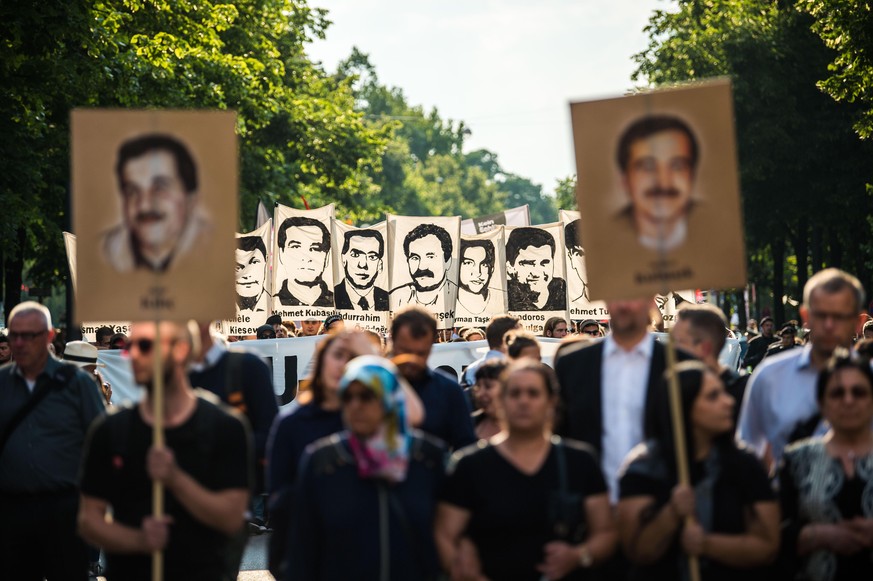 Im Anschluss an das Urteil im NSU-Prozess 2018 ziehen Demonstranten mit Porträts der Ermordeten durch München.