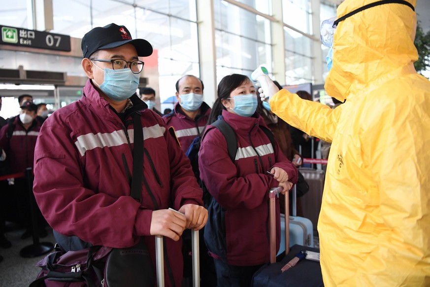 Am Flughafen von Lanzhou wird kurz vor dem Abflug die Temperatur der medizinischen Helfer gemessen.