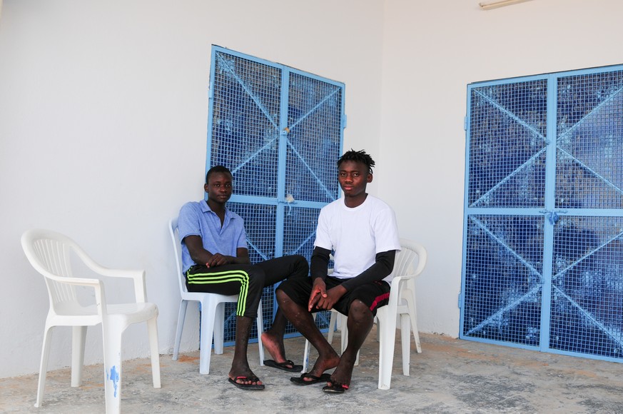 Mamadou Kamarra (l), und Ousmane Koulibali, beide aus Mali, sitzen auf einer Terasse. Kamarra und Koulibali sind zwei Überlebende eines aktuellen Schiffsunglücks vor der tunesischen Küste, bei dem 83 Menschen gestorben sind.