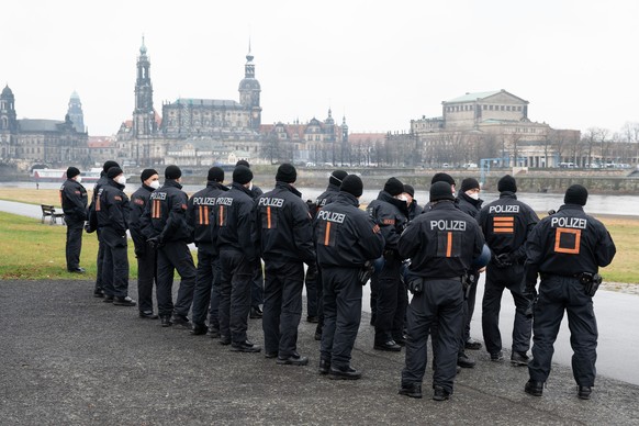 Polizisten stehen am Ufer der Elbe vor der Kulisse der Altstadt. Anlässlich der Landtagssitzung zur Feststellung der epidemischen Lage im Freistaat rechnet die Polizei mit einem Protest von Gegnern de ...