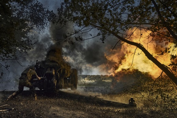 FILE - A Ukrainian policeman of special police unit fires a D-30 cannon towards Russian positions at the front line, near Kreminna, Luhansk region, Ukraine, Friday, July 7, 2023. As the Russian invasi ...