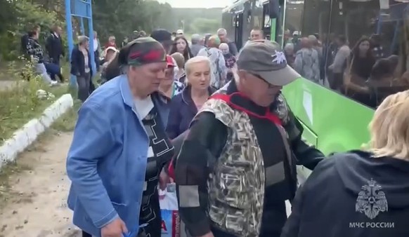 In this image made from video provided by Russian Emergency Situations Ministry press service, people board a bus during evacuation from a fighting between Russian and Ukrainian forces in Belovsky dis ...