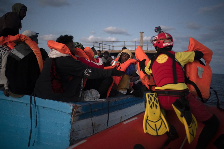 31.12.2020, ---: Migranten, die meisten von ihnen aus Eritrea, bekommen Hilfe von Seenotrettern der spanischen Organisation &quot;Open Arms&quot; (r), nachdem sie auf einem
