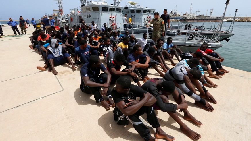 Migrants sit at a naval base after being rescued by Libyan coast guards in Tripoli, Libya July 3, 2018. REUTERS/Ismail Zitouny