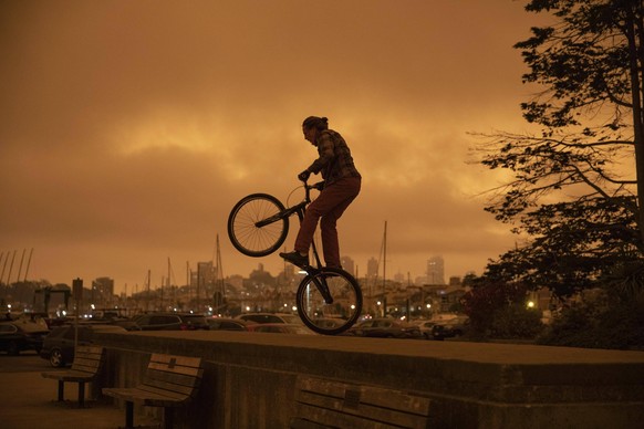 SAN FRANCISCO, CALIFORNIA - SEPTEMBER 09: A man rides a bicycle on the beach as smoke from California wildlife hangs over the skyline on September 9, 2020 in San Francisco, California. PUBLICATIONxINx ...